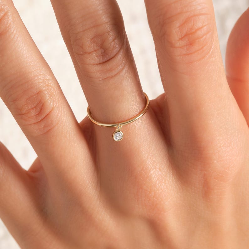 💎 Diamond Dangle Ring – Minimalist 14K Solid Gold Gift for Her
Add effortless sparkle to your everyday style with this diamond dangle ring – a dainty and elegant piece crafted in your choice of 10K, 14K, or 18K solid gold. Featuring a single round-cut diamond or moissanite, this delicate dangling diamond ring brings movement, brilliance, and charm to any look.

Perfect for women who love minimalist jewelry, this handmade gold ring makes a beautiful statement whether worn alone or stacked.