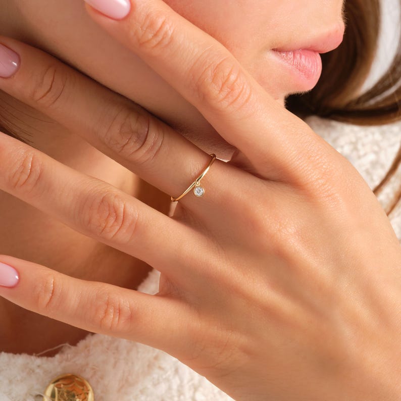 💎 Diamond Dangle Ring – Minimalist 14K Solid Gold Gift for Her
Add effortless sparkle to your everyday style with this diamond dangle ring – a dainty and elegant piece crafted in your choice of 10K, 14K, or 18K solid gold. Featuring a single round-cut diamond or moissanite, this delicate dangling diamond ring brings movement, brilliance, and charm to any look.

Perfect for women who love minimalist jewelry, this handmade gold ring makes a beautiful statement whether worn alone or stacked.