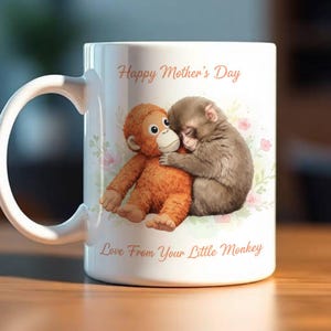 May include: White ceramic mug with a curved handle, featuring a graphic of two monkeys hugging. The text "Happy Mother's Day" and "Love From Your Little Monkey" are printed in a script font. Floral accents are also present.