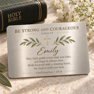 May include: A rectangular brushed silver metal card featuring the engraved text BE STRONG AND COURAGEOUS Joshua 1:9, a gold cross, green olive branches, the name Emily, a religious verse, and the text Confirmation 2026 in gold lettering.