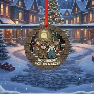 May include: A round Christmas ornament featuring a group of cartoon mice in winter attire. The ornament has the text "NO CHEESES FOR US MEEECES" and is hanging from a red ribbon. The background shows a snowy village scene.