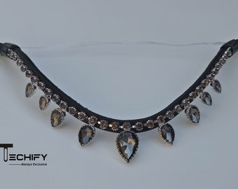 May include: A black leather horse browband with a row of clear rhinestones and dangling teardrop-shaped crystals.