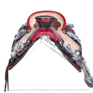 May include: A red and white leather saddle with intricate floral designs and silver accents. The saddle is designed for horseback riding.