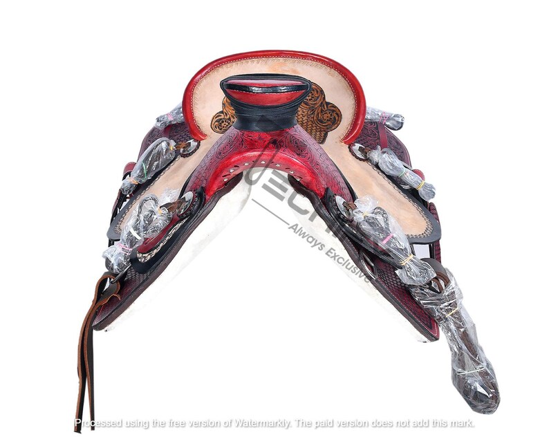 May include: A red and white leather saddle with intricate floral designs and silver accents. The saddle is designed for horseback riding.