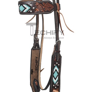 Può includere: Un morso per cavallo in pelle marrone con perline turchesi e bianche. Il morso presenta un design floreale e dettagli argentati.