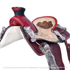 May include: A red and black leather saddle with intricate floral tooling. The saddle features a white fleece seat and a dark brown leather stirrup.