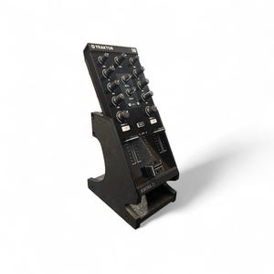 May include: Black DJ controller with knobs, sliders, and buttons, mounted on a black stand. The controller has the Traktor logo at the top and the text "Kontrol Z1" at the bottom. The stand is angled for easy access.