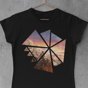 Könnte beinhalten: Schwarzes T-Shirt mit geometrischem Design, das eine Berglandschaft mit Sonnenuntergangshimmel zeigt.