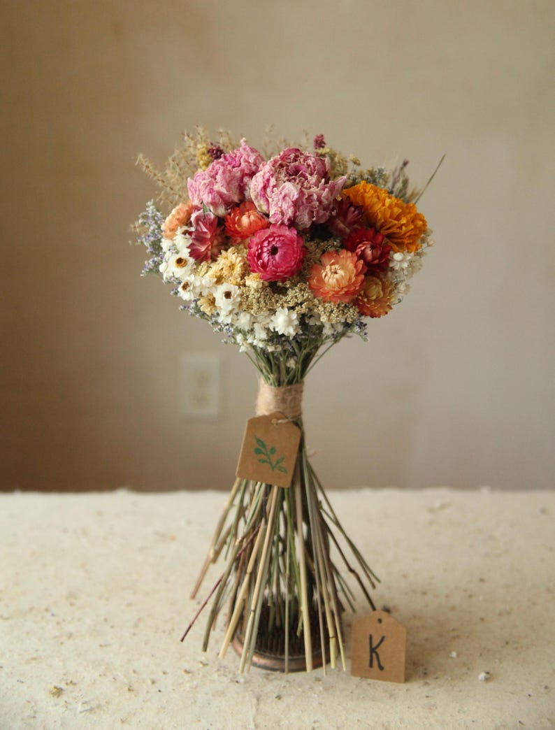 This photo features variation K in a size medium with pink peonies, and orange marigold, daisies, strawflowers and mixed wildflowers and grasses. Organic and naturally air dried flowers. A good size for a bridesmaid, maid of honor, or bridal bouquet, or for a large vase table centerpiece. Mother's Day and Easter florals.
