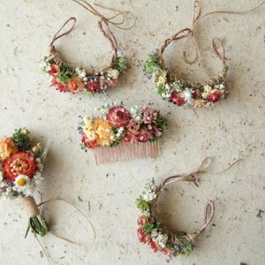 Custom autumnal boutonniere, wrist corsages and hair comb in bright orange tones, accented with baby's breath and greenery. Naturally preserved and air dried florals. Custom wildflower wedding decor.