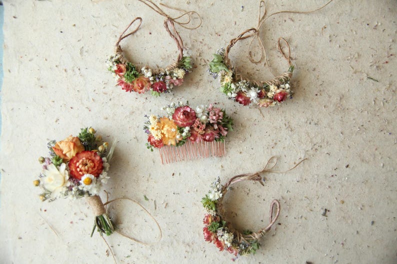 Custom autumnal boutonniere, wrist corsages and hair comb in bright orange tones, accented with baby's breath and greenery. Naturally preserved and air dried florals. Custom wildflower wedding decor.