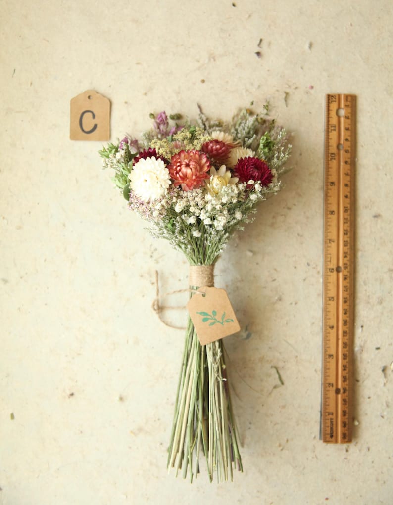 This photo features variation C, a petite dried flower bouquet with peach, burgundy, and  creamy white strawflowers, daisies and wildflowers. Cottage garden wedding florals, Mother's Day and home decor.