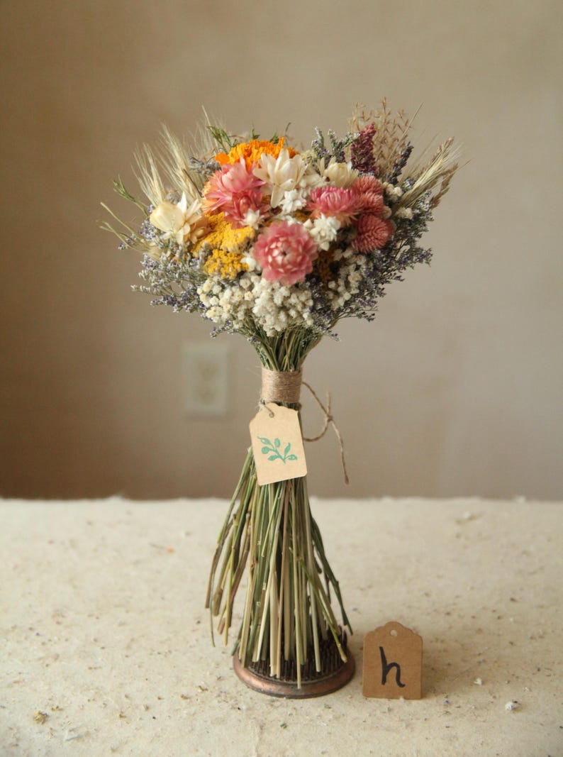 This bouquet features variation H of the listing, with an orange marigold and mix of pink, white and orange strawflowers, ammobium daisies, wildflowers and wild grasses. Size is a Petite Full . Mother's Day, wildflower wedding, bridesmaid proposal floral gifts.