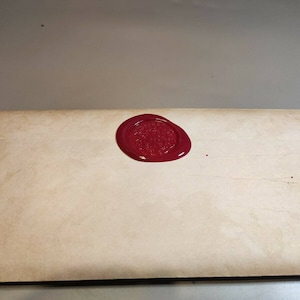 May include: A vintage-style envelope with a red wax seal. The seal has a raised design.
