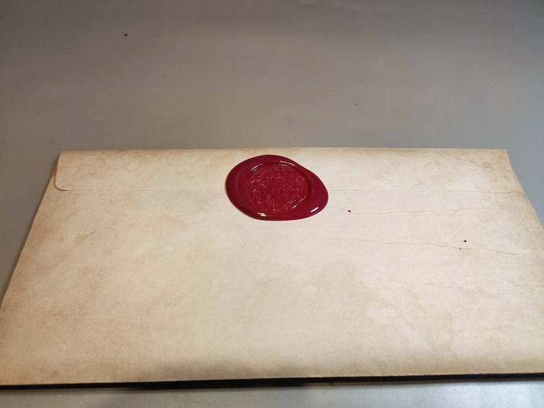 May include: A vintage-style envelope with a red wax seal. The seal has a raised design.