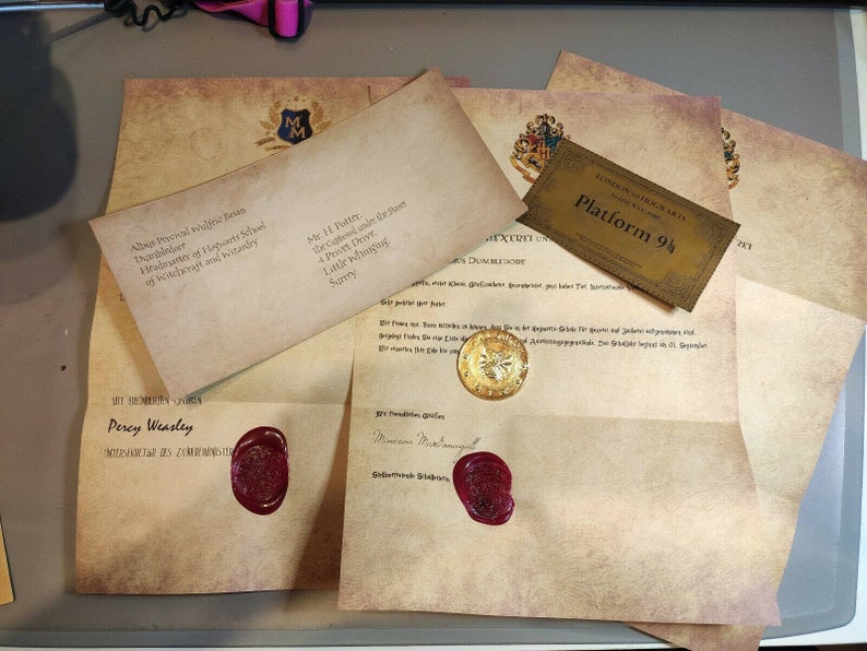 May include: A stack of old, yellowed paper envelopes with red wax seals. The envelopes are addressed to Mr. H. Potter and Percy Weasley. The top envelope has a Hogwarts crest and the text "Albus Percival Wulfric Brian Dumbledore, Headmaster of Hogwarts School of Witchcraft and Wizardry". A gold ticket with the text "London to Hogwarts Express Platform 9 3/4" is visible in the background.