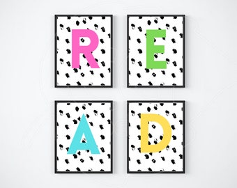 May include: Four black framed prints with a white background and black brushstrokes. Each print features a different colored letter, spelling out the word "READ". The letters are pink, green, blue, and yellow.