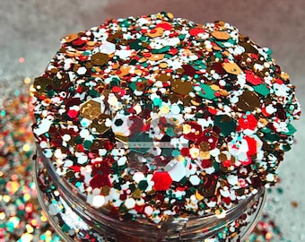 May include: A close-up of a jar filled with red, green, gold, and white glitter. The glitter is a mix of different shapes and sizes.