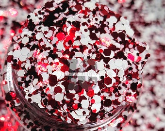 May include: Red and white glitter in a jar. The glitter is in a variety of sizes and shapes.