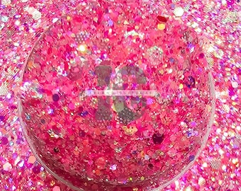 May include: A close-up of pink, iridescent glitter with a variety of sizes and shapes. The glitter is in a clear container and is perfect for crafting projects.