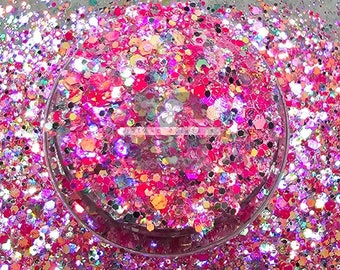 May include: A close-up of a variety of pink, white, and iridescent glitter. The glitter is in a round container and is ideal for crafting projects.
