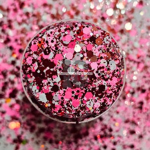May include: A close-up of a mix of red, pink, white, and gold glitter. The glitter is in a clear container and is perfect for crafting projects.