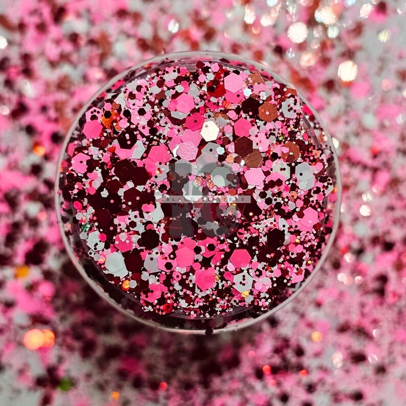 May include: A close-up of a mix of red, pink, white, and gold glitter. The glitter is in a clear container and is perfect for crafting projects.