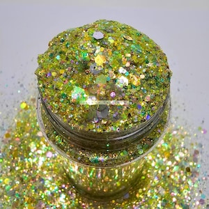 Könnte beinhalten: Ein klares Glasgefäß gefüllt mit grünem, goldenem und schimmerndem Glitter. Der Glitter ist lose und hat verschiedene Größen und Formen.