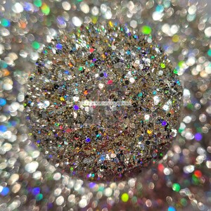 May include: A close-up of a sparkly, iridescent glitter mix with a variety of colors, including gold, silver, pink, and blue.