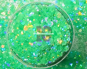 May include: Green glitter with iridescent shimmer. The glitter is in a clear container.