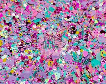 Könnte beinhalten: Nahaufnahme einer Mischung aus bunten Glitzer in verschiedenen Formen und Größen. Der Glitzer enthält rosa, lila, türkis, gelbe und irisierende Teile. Das Bild hat einen weichen Fokus, der die Textur und den Glanz des Glitzers hervorhebt.