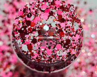 Könnte beinhalten: Nahaufnahme eines Glases gefüllt mit rosa, rotem und weißem Glitzer. Der Glitzer ist eine Mischung aus verschiedenen Formen und Größen.