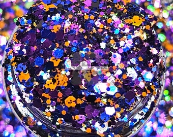Könnte beinhalten: Nahaufnahme eines Glases gefüllt mit buntem Glitter. Der Glitter ist eine Mischung aus Schwarz, Lila, Blau, Orange und Silber. Der Glitter ist perfekt zum Basteln und zum Verzieren von Projekten.