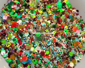 May include: A close-up of a mix of colorful glitter, including red, green, gold, blue, and silver. The glitter is in a variety of shapes and sizes.