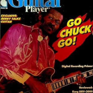 May include: A magazine cover featuring a black man playing a brown and black electric guitar. The magazine is titled "Guitar Player" and the cover text reads "Go Chuck Go!" and "Digital Recording Primer".