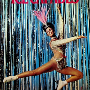 Könnte beinhalten: Eine Frau in einem glitzernden, gold-weißen Kostüm mit einem rosa Federkopfschmuck springt in die Luft. Sie trägt weiße Schlittschuhe und steht vor einem blau-weiß gestreiften Hintergrund. Der Text "ICE CAPADES" befindet sich oben im Bild.