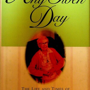 May include: Book cover with the title "Any Given Day" in elegant script over a green background. Below, a portrait of an elderly woman in a red jacket is featured. The book is a memoir of twentieth-century America.