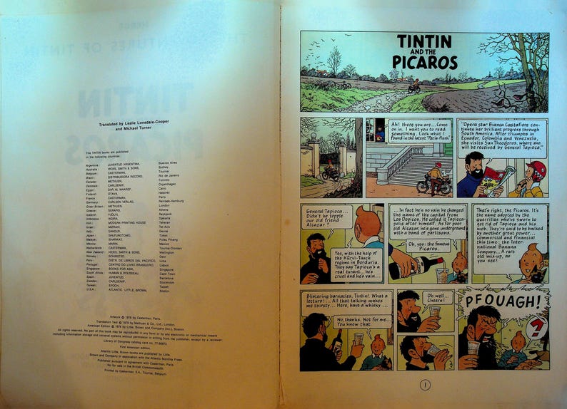 May include: Open book with comic strip panels from "Tintin and the Picaros." The title is displayed at the top. The left page lists the countries where the book was published. The comic panels depict scenes with characters and speech bubbles.