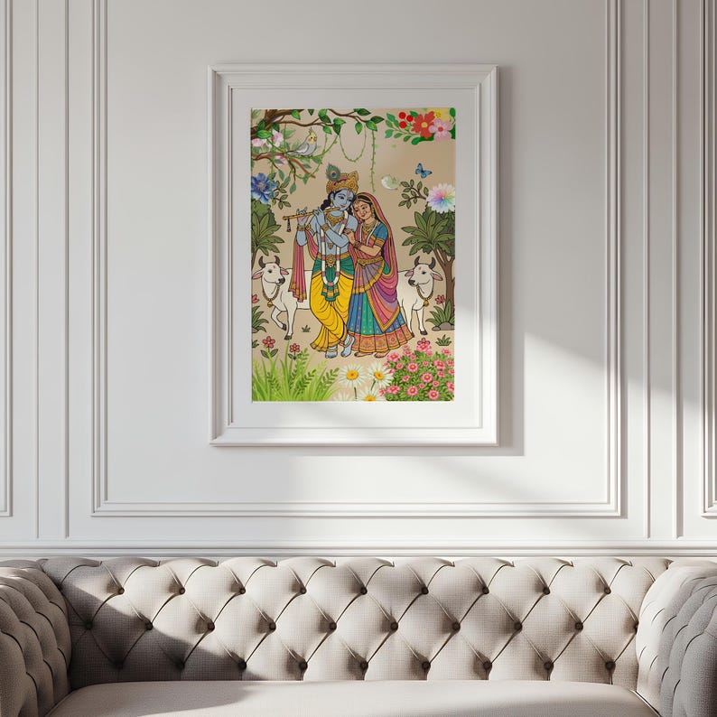 May include: Framed artwork depicting a couple in traditional Indian attire, surrounded by cows, flowers, and foliage. The artwork features vibrant colors, including yellow, blue, and pink, and is set against a neutral background. The frame is white.