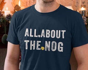 May include: A navy blue t-shirt with the text "ALL ABOUT THE NOG" in white with a yellow coffee cup icon.
