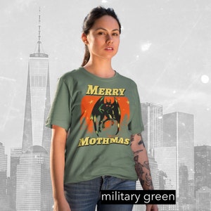 May include: A green t-shirt with a graphic of a monster with the text "Merry Mothmas".