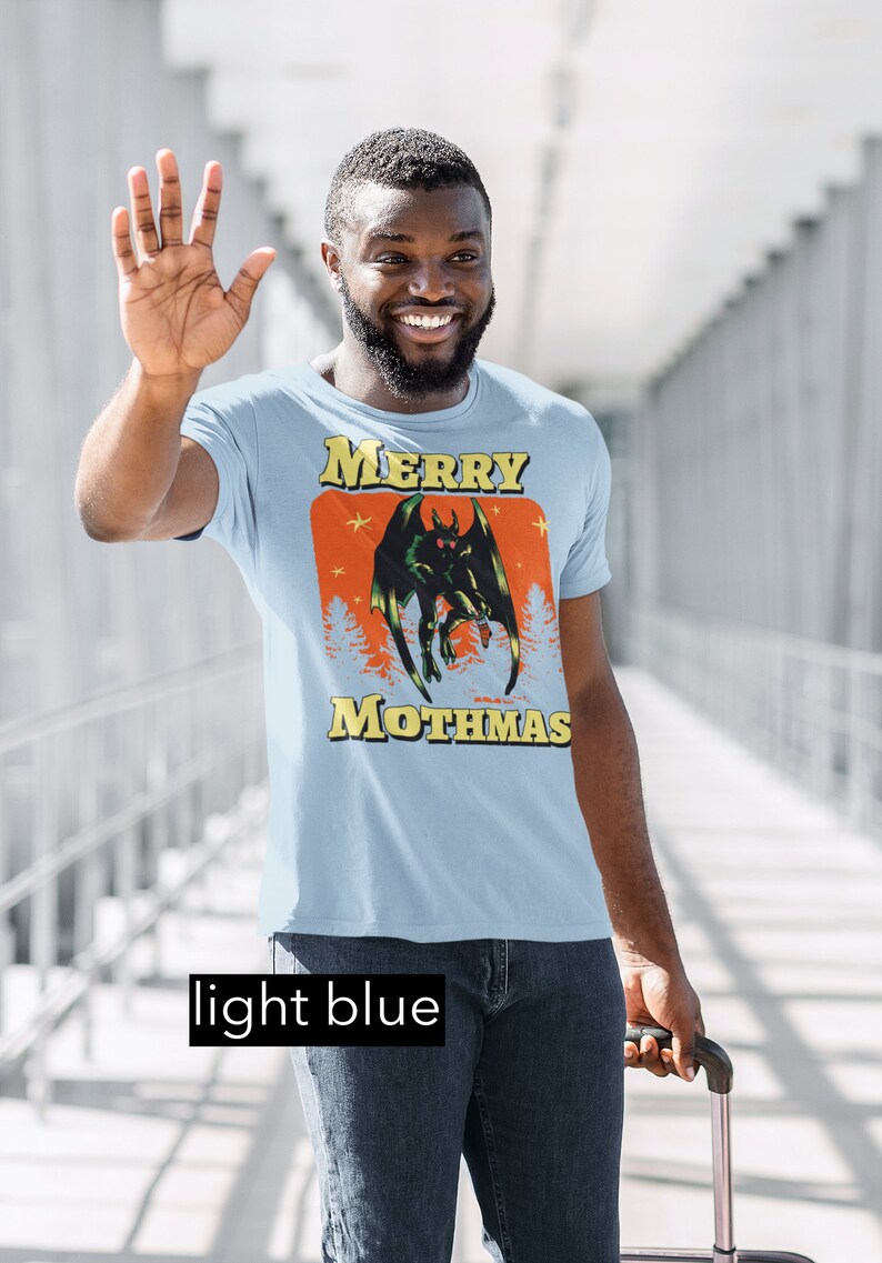 May include: A light blue t-shirt with a graphic of a green monster with red eyes and the text "Merry Mothmas".