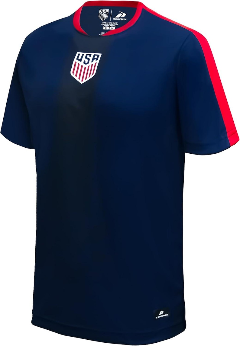 May include: Navy blue athletic t-shirt with red accents. Features the USA logo on the chest and red stripes on the sleeves. The shirt has a crew neck with a red trim and a small logo on the lower right.