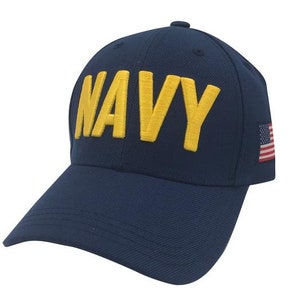 May include: A navy blue baseball cap with a yellow embroidered "NAVY" on the front and a small American flag on the side.