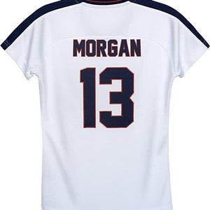 Peut inclure: Maillot de sport blanc avec le nom "MORGAN" et le num&eacute;ro "13" en bleu marine avec une bordure rouge. Le maillot a des d&eacute;tails bleu marine sur les &eacute;paules et l'encolure. Le maillot est fait d'un tissu l&eacute;ger et respirant.
