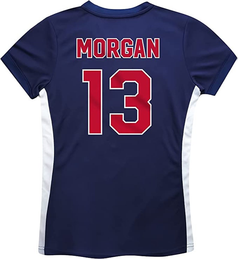 Pu&ograve; includere: Una maglia a maniche corte blu navy con pannelli laterali bianchi. Sul retro della maglia &egrave; stampato il nome "MORGAN" e il numero "13" in rosso.