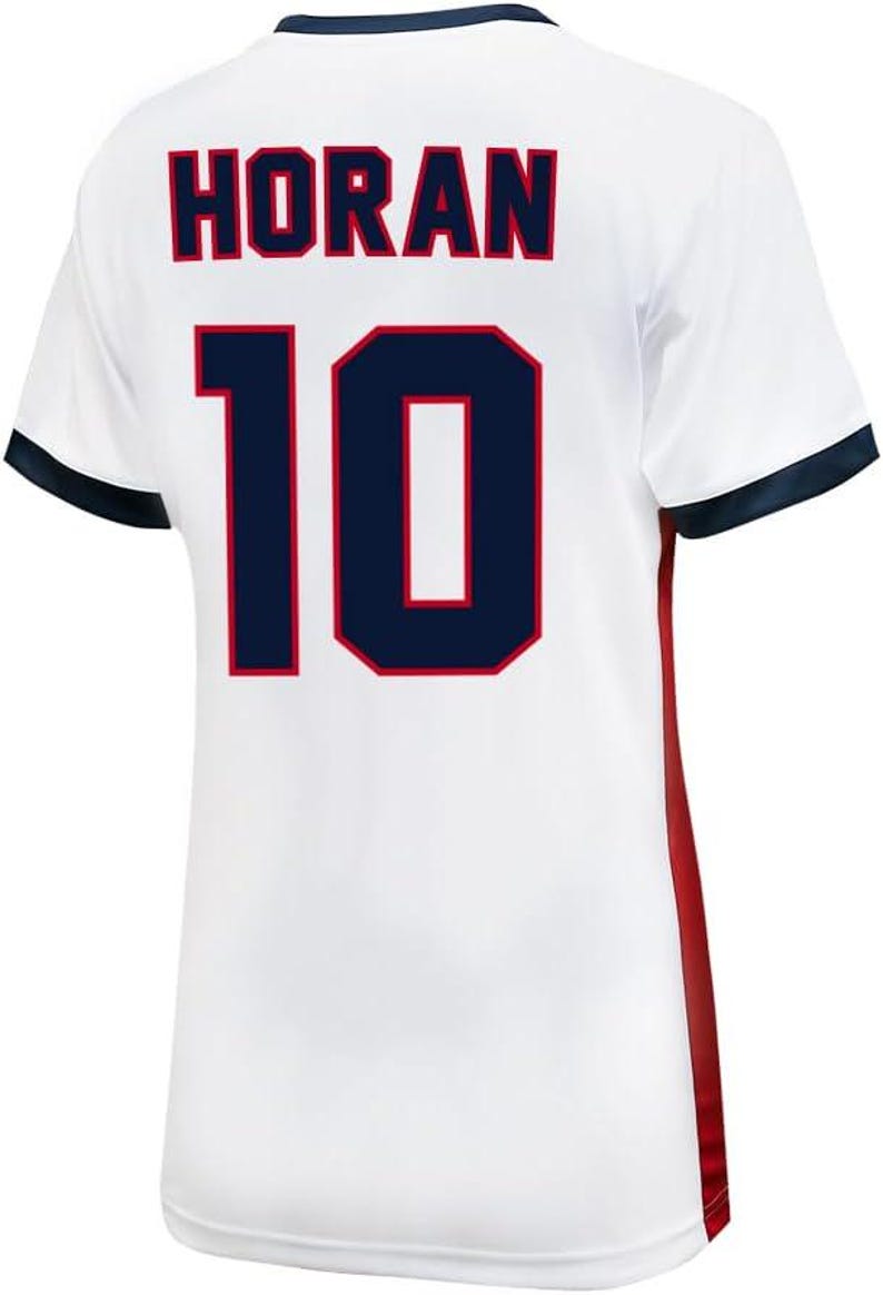 Pu&ograve; includere: Maglia da calcio bianca con bordini blu e rossi. Sul retro della maglia &egrave; presente il nome "HORAN" e il numero "10" in blu scuro con contorno rosso.