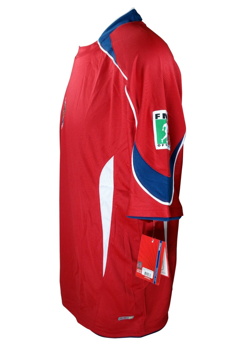 May include: Red soccer jersey with white and blue accents. The jersey has a small logo on the left chest and a larger logo on the right sleeve that says "FIFA Official".