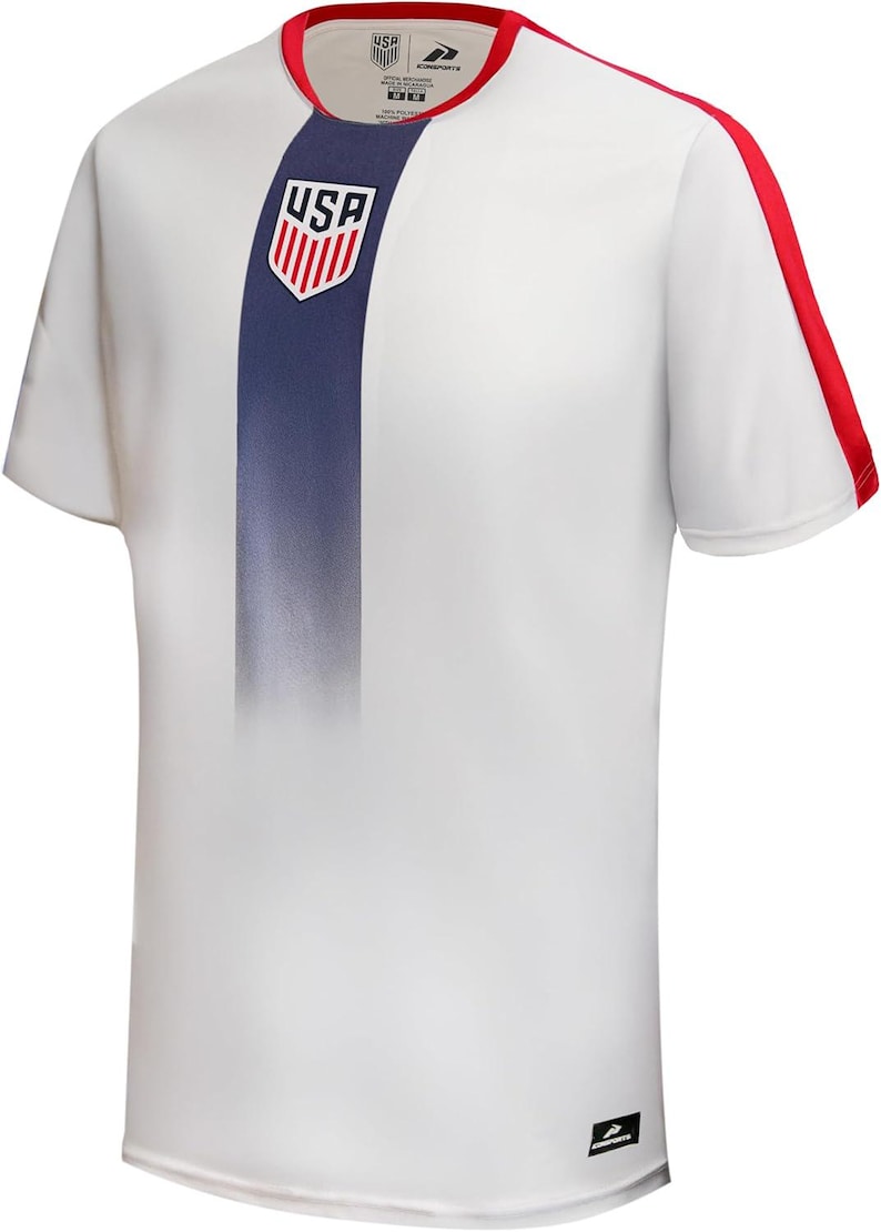 May include: White athletic t-shirt with a blue vertical stripe down the front, featuring the USA logo. Red accents are on the sleeves and collar. The shirt is short-sleeved.