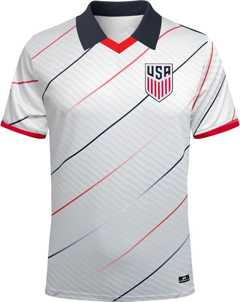 May include: White football shirt with diagonal red and blue stripes. The shirt features a navy blue collar with a red V-neck and red sleeve cuffs. The USA emblem is on the chest.